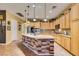 Spacious kitchen with wooden cabinets, granite countertops, a stone island base, and modern appliances at 3801 W Hammer Ln, North Las Vegas, NV 89031