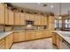 Bright kitchen with wooden cabinets, granite countertops, a breakfast bar, and stainless steel appliances at 3801 W Hammer Ln, North Las Vegas, NV 89031
