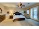 Spacious main bedroom featuring a ceiling fan, dark wood furniture, and French doors to the backyard at 3801 W Hammer Ln, North Las Vegas, NV 89031