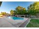 Sparkling pool with a waterfall feature surrounded by lush landscaping and a privacy fence at 3801 W Hammer Ln, North Las Vegas, NV 89031