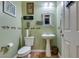 Charming powder room featuring a pedestal sink, decorative mirror, and tasteful wall art at 3801 W Hammer Ln, North Las Vegas, NV 89031