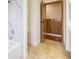 A bathroom displays a tub with white marble-style walls and unique wood paneling on the door at 5516 Cory Pl, Las Vegas, NV 89107