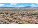 An expansive aerial view shows a thriving community nestled against a backdrop of majestic mountains at 6435 Parrot Ridge Ct, Las Vegas, NV 89139