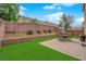 The backyard features artificial turf, a brick paver patio, a seating area, and a low-maintenance landscape at 6435 Parrot Ridge Ct, Las Vegas, NV 89139