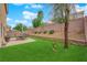 The backyard includes artificial turf, brick paver patio, outdoor seating, and low maintenance landscaping at 6435 Parrot Ridge Ct, Las Vegas, NV 89139