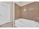 A bathroom with a soaking tub and tile surround, featuring a door at 6435 Parrot Ridge Ct, Las Vegas, NV 89139