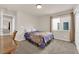 A sunlit bedroom with a blue patterned comforter, carpet, and ample natural light at 6435 Parrot Ridge Ct, Las Vegas, NV 89139