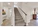 Bright foyer showcasing a staircase with carpeted steps and a dark wood railing at 6435 Parrot Ridge Ct, Las Vegas, NV 89139