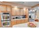 Kitchen featuring stainless steel appliances, oak cabinetry and an island with counter seating at 6491 Bright Nimbus Ave, Las Vegas, NV 89139