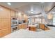 Well-lit kitchen with stainless steel appliances, oak cabinetry and an island with counter seating at 6491 Bright Nimbus Ave, Las Vegas, NV 89139