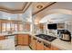 Well-equipped kitchen with stainless appliances, tile countertops, and a cooktop island at 6491 Bright Nimbus Ave, Las Vegas, NV 89139
