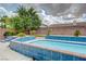 Inviting backyard pool featuring blue tiling, lush greenery, and a secure brick perimeter, perfect for outdoor enjoyment at 6491 Bright Nimbus Ave, Las Vegas, NV 89139