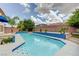 A backyard swimming pool featuring a blue tile trim, palm trees and patio at 6491 Bright Nimbus Ave, Las Vegas, NV 89139