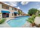 A backyard swimming pool featuring a blue tile trim, palm trees, patio, and views of the home at 6491 Bright Nimbus Ave, Las Vegas, NV 89139