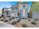 Modern two-story home with a neutral color scheme, rock landscaping, and a paved walkway at 7476 Moonglade St, North Las Vegas, NV 89084