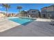 Community pool with palm trees, lounge chairs, and secure fencing providing a perfect place for residents to relax and enjoy at 7476 Moonglade St, North Las Vegas, NV 89084