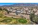 Aerial view of desert golf community with well-spaced homes with mature trees and desert landscaping, mountain backdrop at 7567 Wingspread St, North Las Vegas, NV 89084