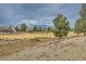 Backyard view of community space, dry landscaping, mature trees, and nearby homes at 7567 Wingspread St, North Las Vegas, NV 89084
