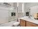 Well-lit bathroom with a shower-tub combo, wood vanity, and decorative wall accents at 7567 Wingspread St, North Las Vegas, NV 89084