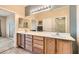 Bathroom with a double sink vanity, large mirror with Hollywood lighting, and a walk-in closet at 7567 Wingspread St, North Las Vegas, NV 89084