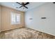 Cozy bedroom featuring plush carpeting, a ceiling fan, and a window with stylish shutters at 7567 Wingspread St, North Las Vegas, NV 89084