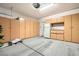 Spacious garage featuring ample storage cabinets, a refrigerator, and pegboard organizational system at 7567 Wingspread St, North Las Vegas, NV 89084