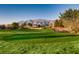 Scenic golf course with lush green grass, blue skies, and mountain views in the background at 7567 Wingspread St, North Las Vegas, NV 89084