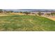 Lush green golf course with desert landscape and mountain views with houses in the background under a cloudy sky at 7567 Wingspread St, North Las Vegas, NV 89084