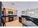 A kitchen featuring wood cabinets, granite countertops, tile backsplash, stainless steel appliances, and tile flooring at 7567 Wingspread St, North Las Vegas, NV 89084