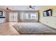 An inviting living room features ample natural light, tile flooring, neutral paint, and a carpet area for comfort at 7567 Wingspread St, North Las Vegas, NV 89084