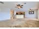 Open-concept living space with kitchen access, carpet, ceiling fans, and natural light from windows at 7567 Wingspread St, North Las Vegas, NV 89084