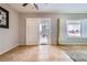 A living room featuring tile flooring, a sliding door, a ceiling fan, and sunlit windows at 7567 Wingspread St, North Las Vegas, NV 89084