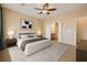Bright main bedroom featuring a ceiling fan, and an open doorway to an ensuite bathroom at 7567 Wingspread St, North Las Vegas, NV 89084