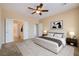 Bright main bedroom featuring a ceiling fan, a serene color scheme, and an open doorway to the ensuite bathroom at 7567 Wingspread St, North Las Vegas, NV 89084