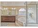 Elegant bathroom features a soaking tub with a unique tile window and glass enclosed shower at 7581 Slipstream St, Las Vegas, NV 89139
