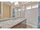 Well-lit bathroom featuring a granite countertop, vanity, and tiled shower-tub combo at 7581 Slipstream St, Las Vegas, NV 89139