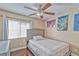 Cozy bedroom features a bed, ceiling fan, window and simple decor at 7581 Slipstream St, Las Vegas, NV 89139