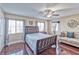 Comfortable bedroom with hardwood floors, sitting area, and natural light from large windows at 7581 Slipstream St, Las Vegas, NV 89139
