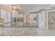 A bright kitchen showcasing granite countertops, white cabinets, and modern appliances with stairs in view at 7581 Slipstream St, Las Vegas, NV 89139