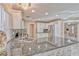 A well-lit open concept kitchen featuring granite countertops, stainless steel appliances, and white cabinetry at 7581 Slipstream St, Las Vegas, NV 89139