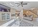 Bright living room with stone fireplace, modern ceiling fan, tile floors, and access to the kitchen at 7581 Slipstream St, Las Vegas, NV 89139
