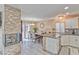 A well-lit open concept dining and living area featuring a stone fireplace and a modern kitchen at 7581 Slipstream St, Las Vegas, NV 89139