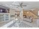 Bright living room with stone fireplace, modern ceiling fan, tile floors, and access to the kitchen at 7581 Slipstream St, Las Vegas, NV 89139