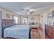 Comfortable primary bedroom with wood floors, ceiling fan, seating, and natural light at 7581 Slipstream St, Las Vegas, NV 89139