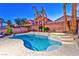 Backyard oasis featuring a sparkling pool, spa, palm trees, and landscape at 7581 Slipstream St, Las Vegas, NV 89139