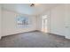 Spacious bedroom featuring gray carpeting, a large window, and bright, neutral walls at 800 Fetter Ct, Henderson, NV 89052