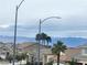View of the community highlighting well-maintained homes, palm trees and a mountain range in the background at 800 Fetter Ct, Henderson, NV 89052