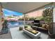 Covered patio with outdoor seating, fireplace, and view of the pool and landscaped backyard at 800 Fetter Ct, Henderson, NV 89052
