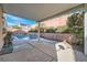 Inviting backyard pool with rock features, lush landscaping, and a view of the home's rear exterior at 800 Fetter Ct, Henderson, NV 89052
