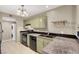 Galley kitchen with green cabinetry, black appliances, granite countertops and tile floor at 8400 Majestic View Ave, Las Vegas, NV 89129